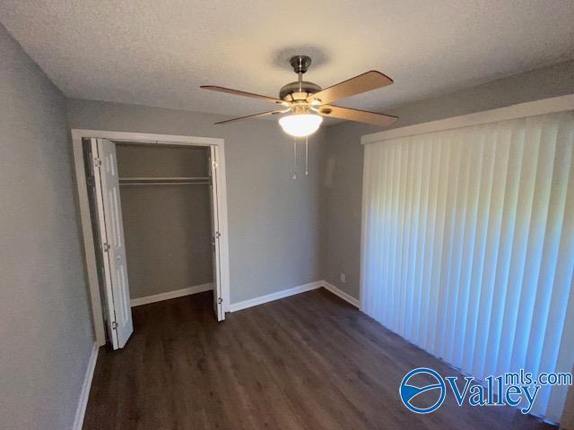 2940 Hood Rd SW Unit I, Huntsville, AL 35805 - unfurnished bedroom with baseboards, a ceiling fan, a closet, and wood finished floors