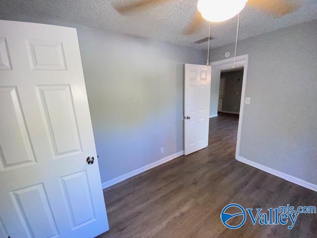 2940 Hood Rd SW Unit I, Huntsville, AL 35805 - unfurnished room with a textured ceiling, a ceiling fan, baseboards, wood finished floors, and visible vents