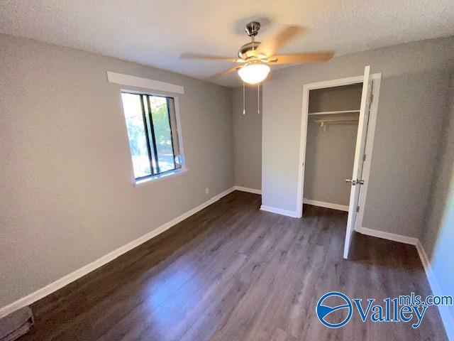 2940 Hood Rd SW Unit I, Huntsville, AL 35805 - unfurnished bedroom with dark wood-style flooring, baseboards, ceiling fan, and a closet