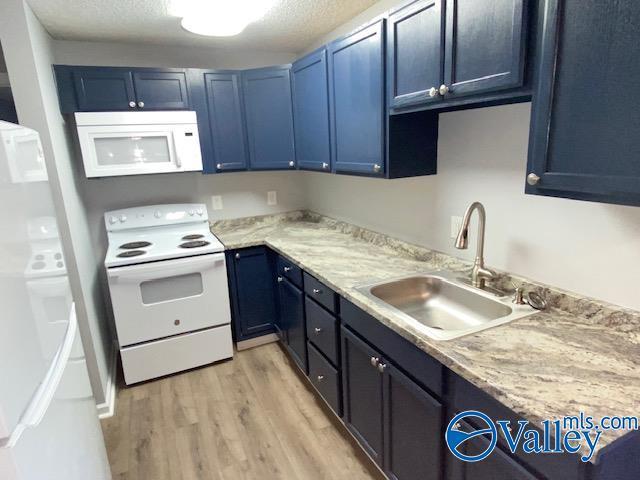 2940 Hood Rd SW Unit I, Huntsville, AL 35805 - kitchen featuring a sink, white appliances, and blue cabinetry