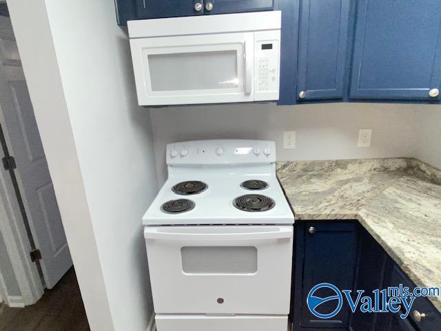 2940 Hood Rd SW Unit I, Huntsville, AL 35805 - kitchen featuring light stone counters, blue cabinets, and white appliances