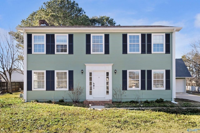 colonial-style house with a garage and a front yard