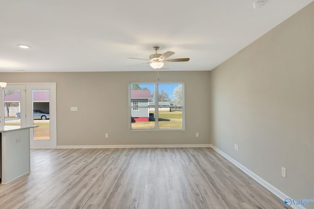 interior space with light wood-type flooring, baseboards, and a ceiling fan