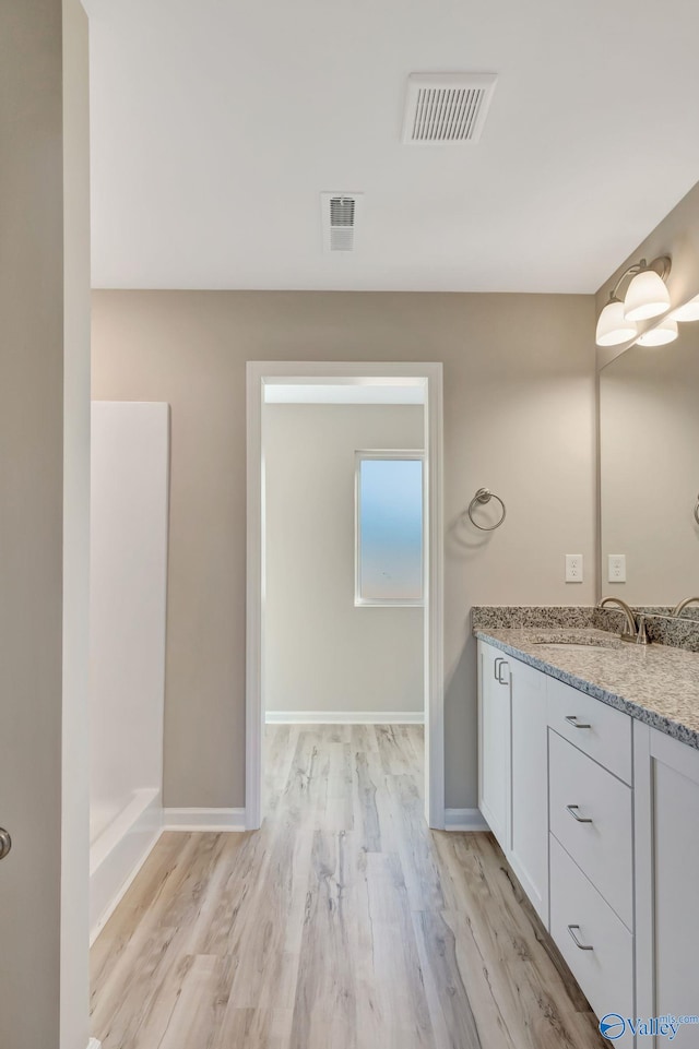 full bathroom featuring visible vents, vanity, baseboards, and wood finished floors