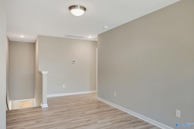 empty room featuring light wood-type flooring and baseboards