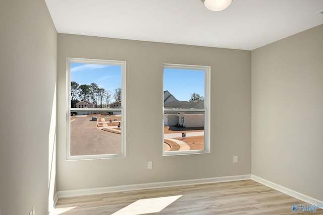 empty room with baseboards and wood finished floors