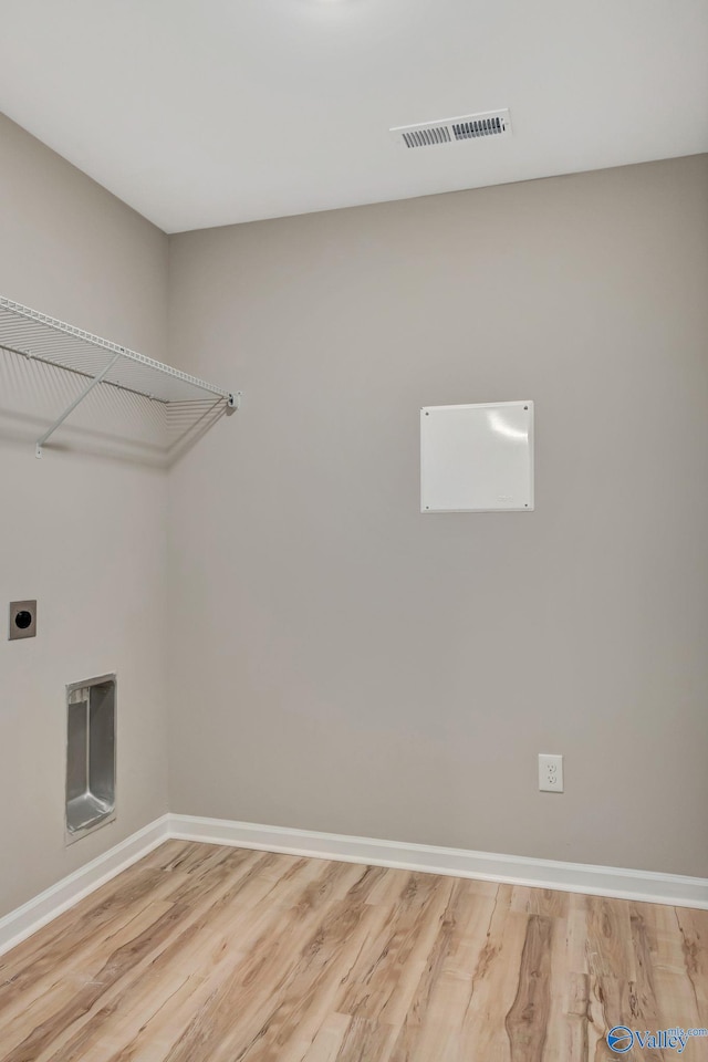 washroom featuring laundry area, electric dryer hookup, light wood-style floors, and visible vents