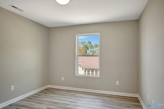 spare room with visible vents, baseboards, and light wood finished floors