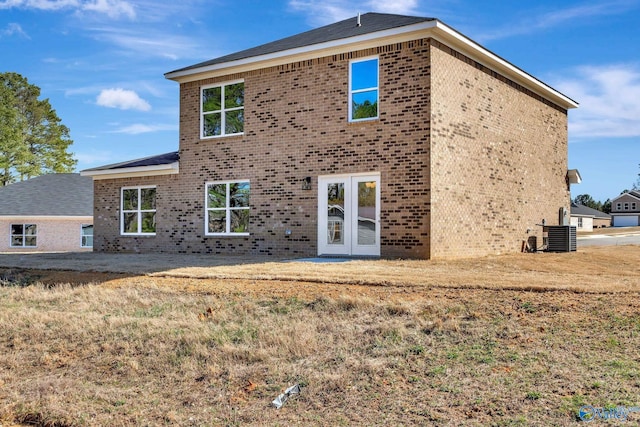 back of house with a yard, brick siding, and french doors