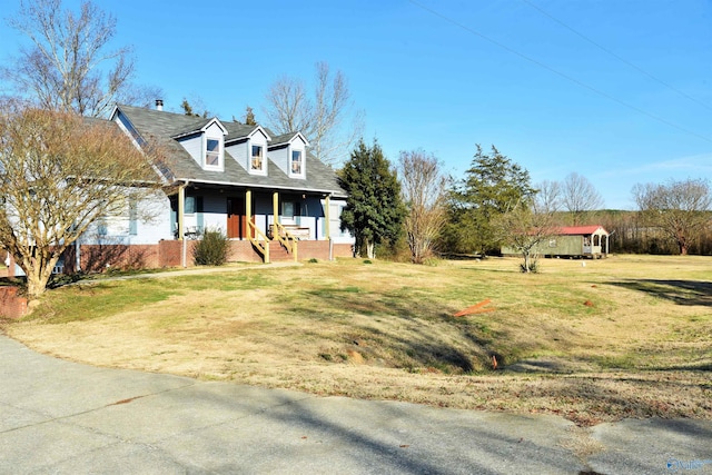 cape cod house with a front yard and covered porch