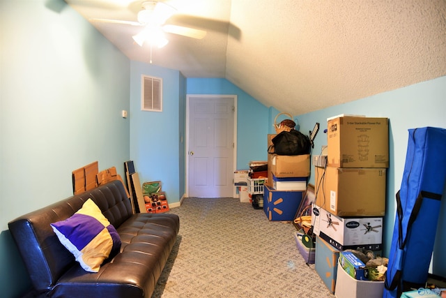 interior space with ceiling fan, carpet, lofted ceiling, and a textured ceiling