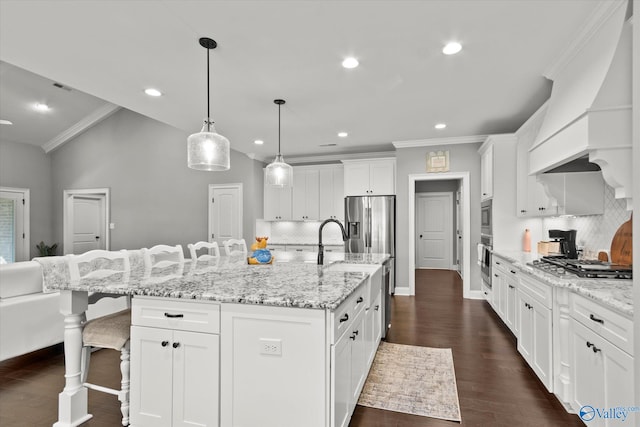 kitchen featuring a large island with sink, white cabinetry, stainless steel appliances, a breakfast bar area, and dark hardwood / wood-style flooring