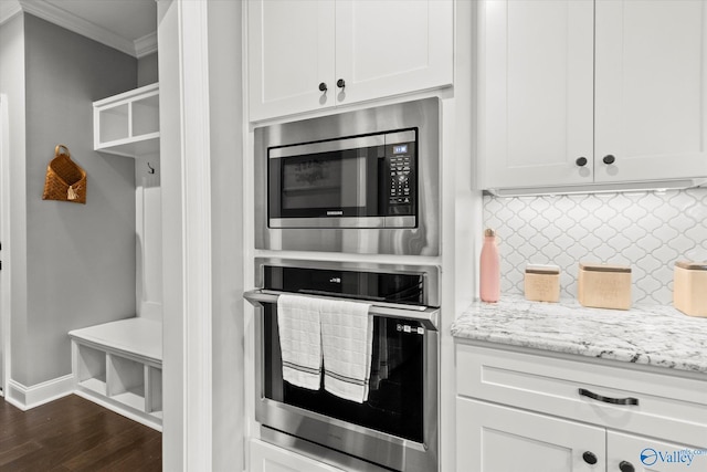 kitchen with white cabinetry, appliances with stainless steel finishes, and light stone counters