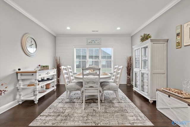 dining area with crown molding, wooden walls, and dark hardwood / wood-style floors