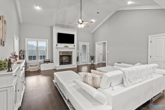 living room featuring dark wood-type flooring, a fireplace, high vaulted ceiling, crown molding, and ceiling fan