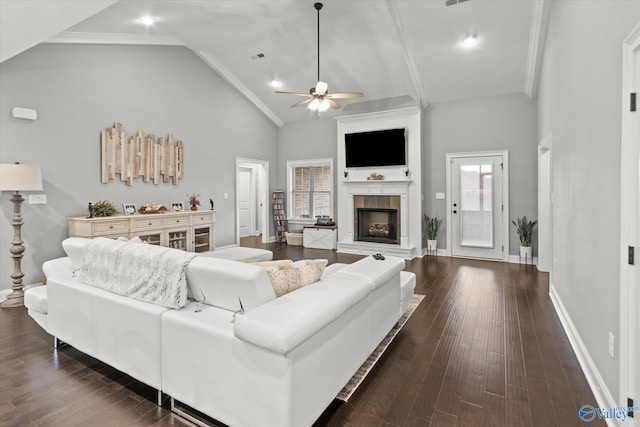 living room featuring ceiling fan, ornamental molding, a tiled fireplace, high vaulted ceiling, and dark hardwood / wood-style flooring