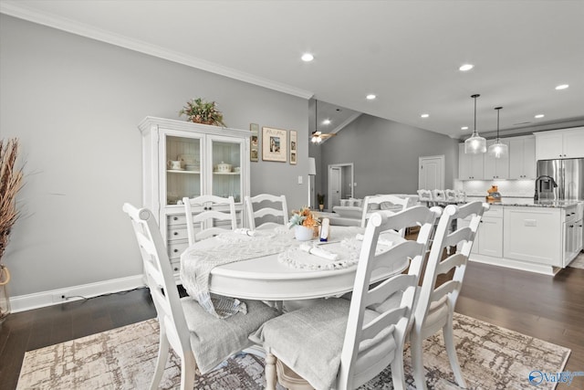 dining area featuring lofted ceiling, dark hardwood / wood-style floors, and ornamental molding