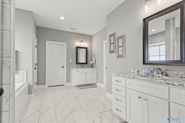 bathroom with a washtub and vanity