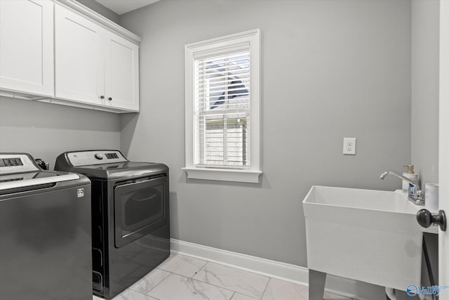 laundry area featuring separate washer and dryer, sink, and cabinets