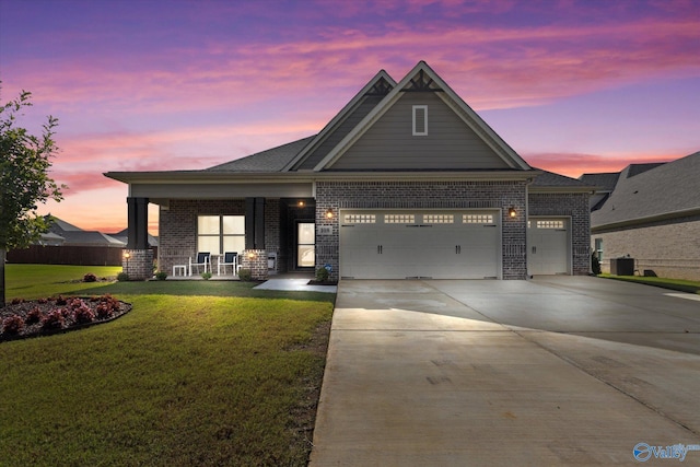 craftsman inspired home featuring a lawn, cooling unit, and a garage