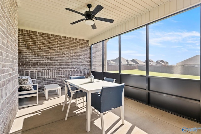 unfurnished sunroom with ceiling fan