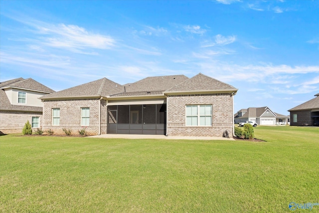 rear view of house with a lawn and a sunroom