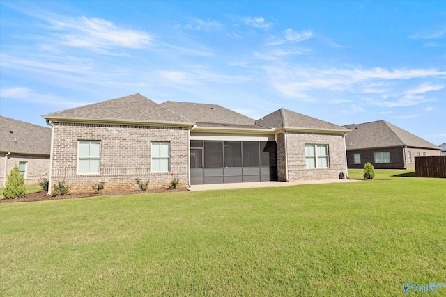 rear view of house with a sunroom and a yard