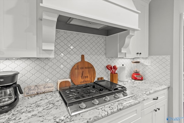 kitchen with decorative backsplash, stainless steel gas cooktop, and white cabinets