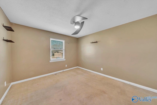 unfurnished room with visible vents, baseboards, and light colored carpet