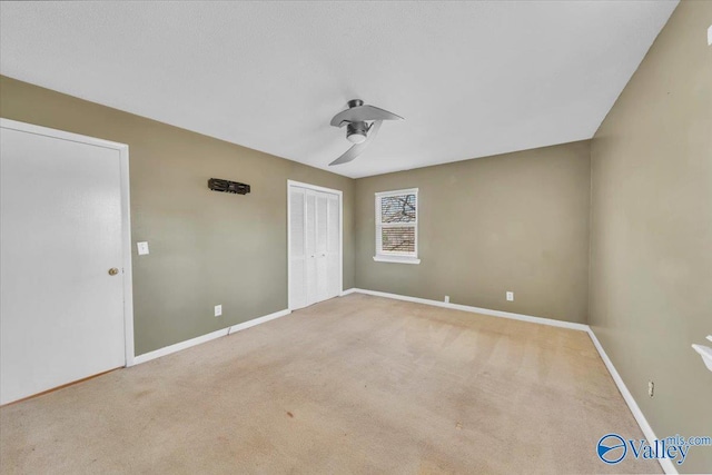 unfurnished bedroom featuring carpet flooring, baseboards, a closet, and ceiling fan