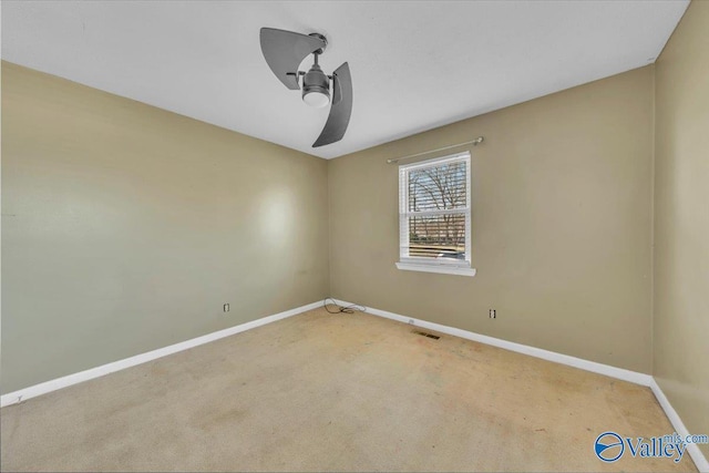 carpeted empty room with visible vents, baseboards, and ceiling fan