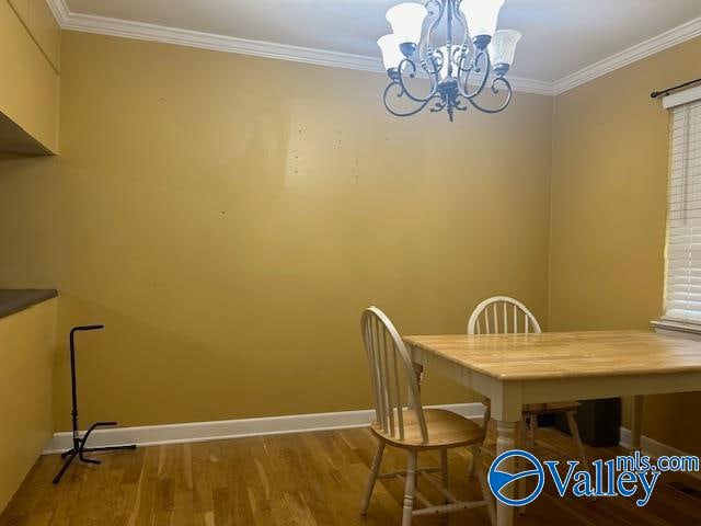 dining area featuring a notable chandelier, wood-type flooring, and crown molding