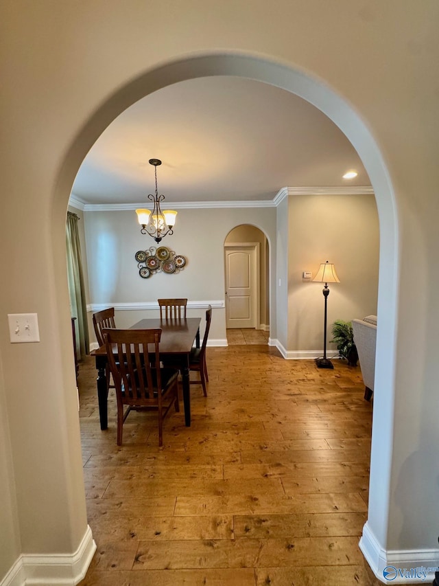 dining room with crown molding, a chandelier, and light hardwood / wood-style floors