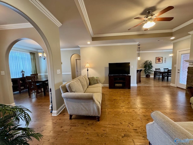 living room featuring ceiling fan with notable chandelier, crown molding, and hardwood / wood-style floors