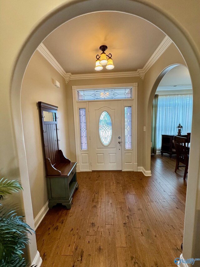 entrance foyer featuring crown molding and wood-type flooring