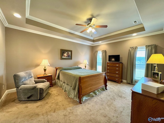 bedroom featuring ornamental molding, light carpet, ceiling fan, and a tray ceiling