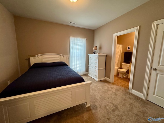 bedroom with light carpet and ensuite bath