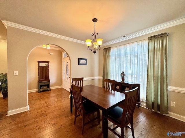 dining room featuring ornamental molding, dark hardwood / wood-style flooring, and a chandelier