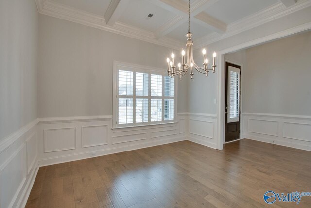 spare room with coffered ceiling, crown molding, beam ceiling, hardwood / wood-style flooring, and a chandelier