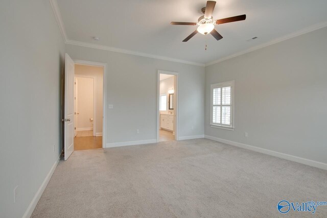 unfurnished bedroom with ceiling fan, light colored carpet, ornamental molding, and connected bathroom