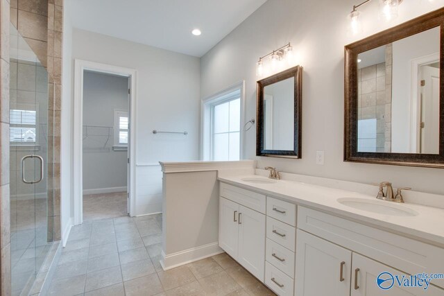 bathroom featuring tile patterned floors, vanity, and a shower with door