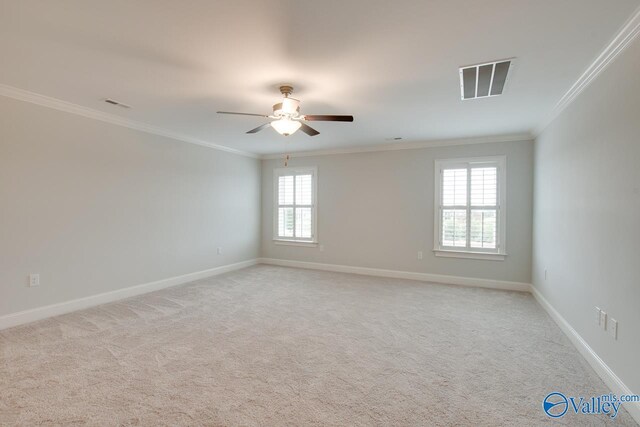 carpeted empty room featuring ceiling fan, plenty of natural light, and ornamental molding