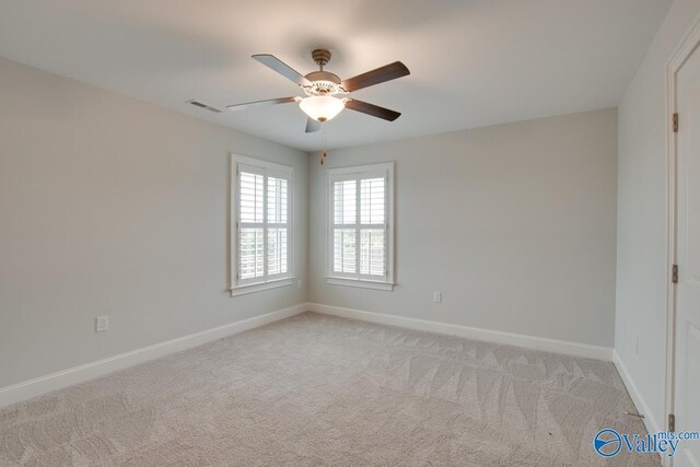 carpeted spare room with ceiling fan