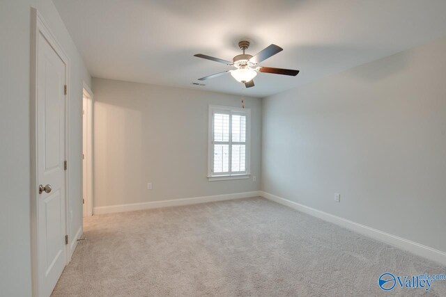 spare room with ceiling fan and light colored carpet