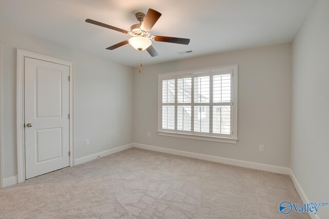 carpeted spare room featuring ceiling fan