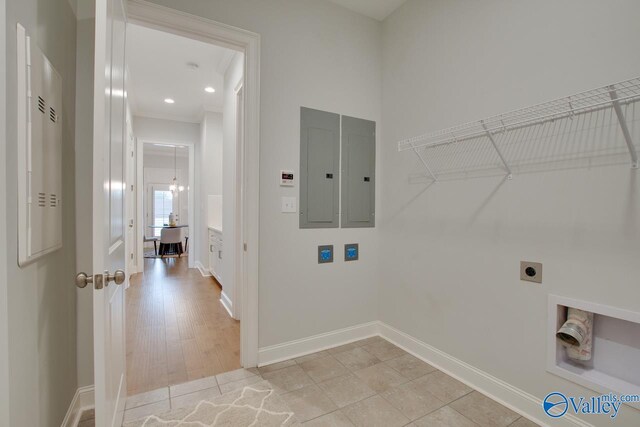 washroom featuring hookup for an electric dryer, electric panel, and light tile patterned flooring