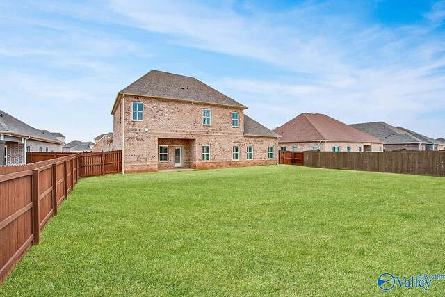 rear view of property with a lawn