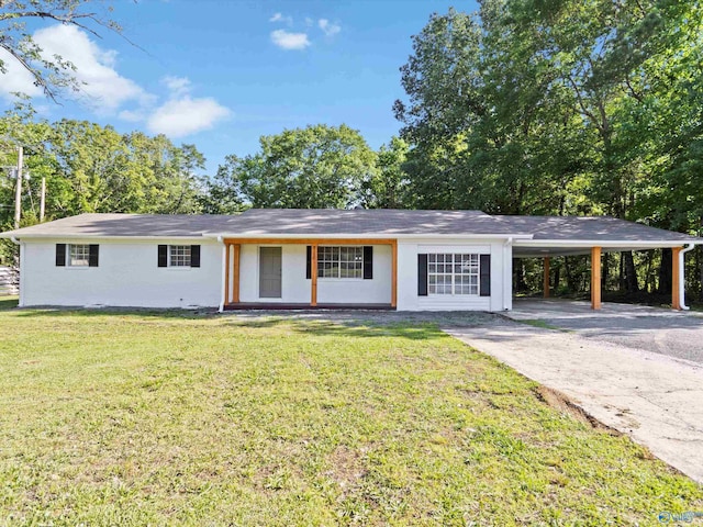 single story home with concrete driveway, an attached carport, and a front yard