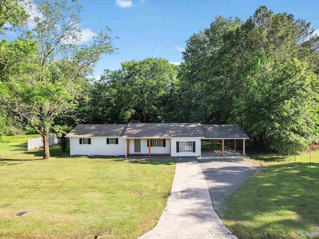 ranch-style house featuring a carport, a front yard, driveway, and fence