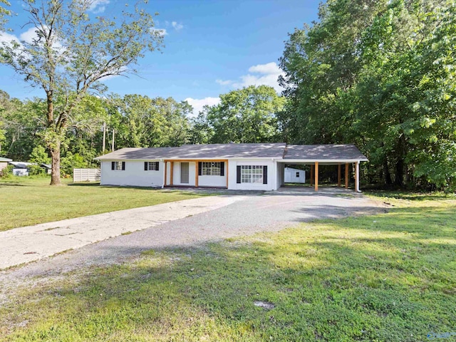 ranch-style home with a carport, driveway, and a front lawn